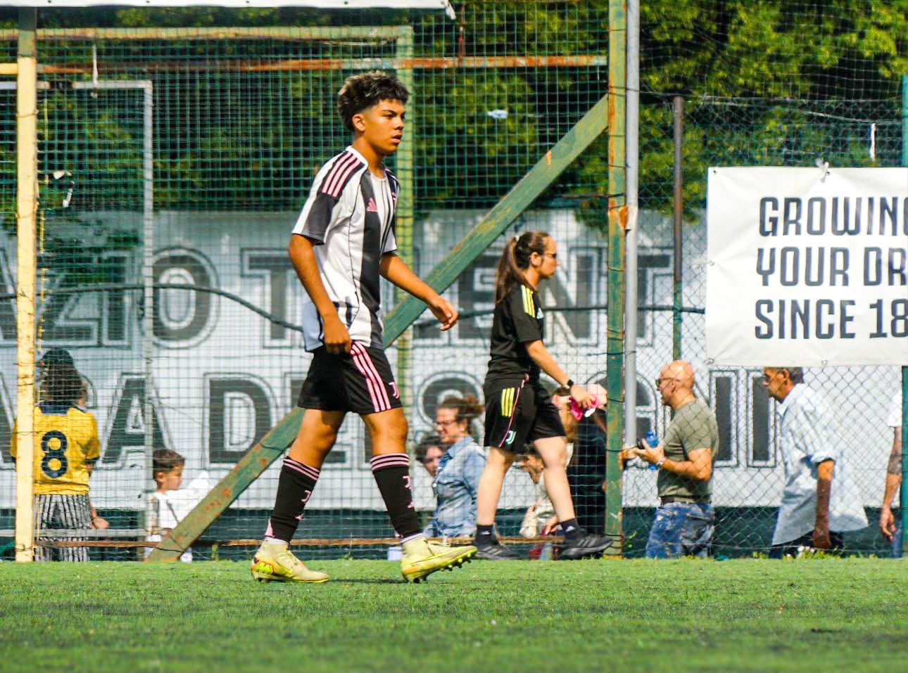 Eric walking the pitch in front of the Growing Your Dreams banner