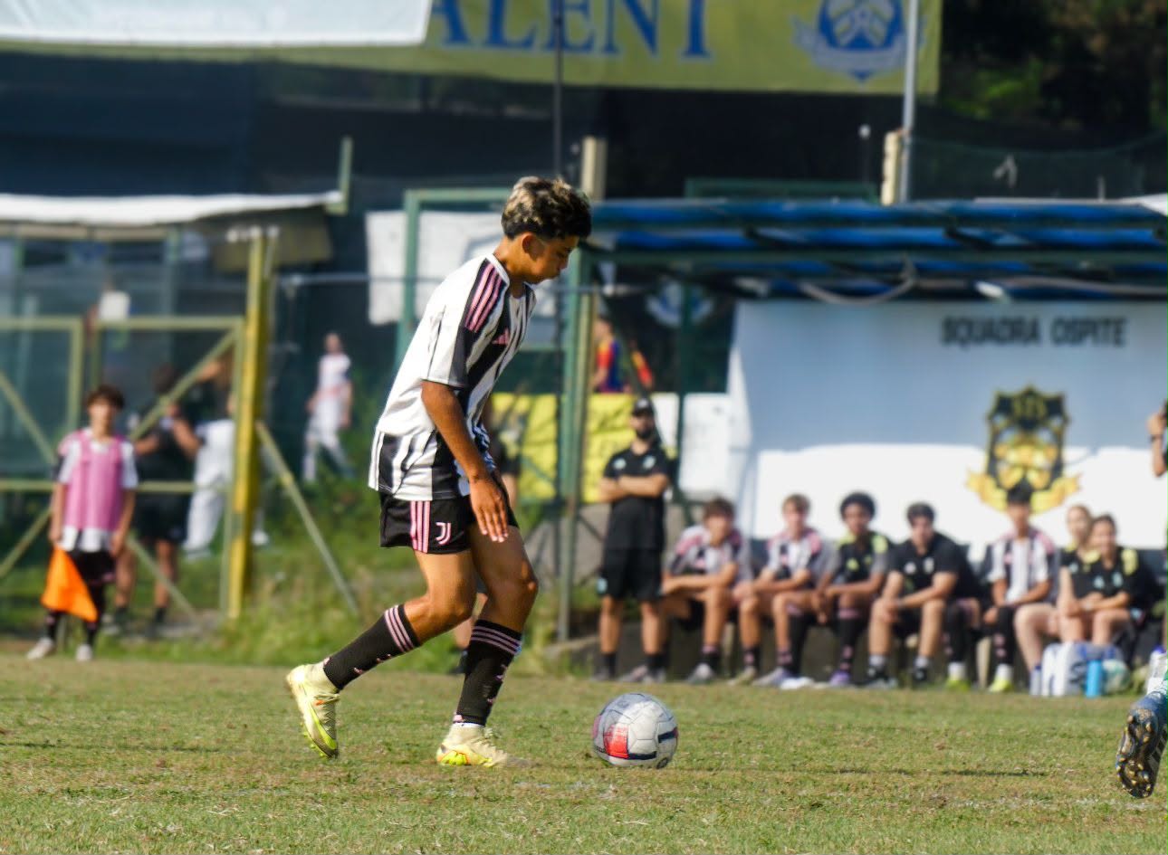 Eric dribbling in front of the Talent banner